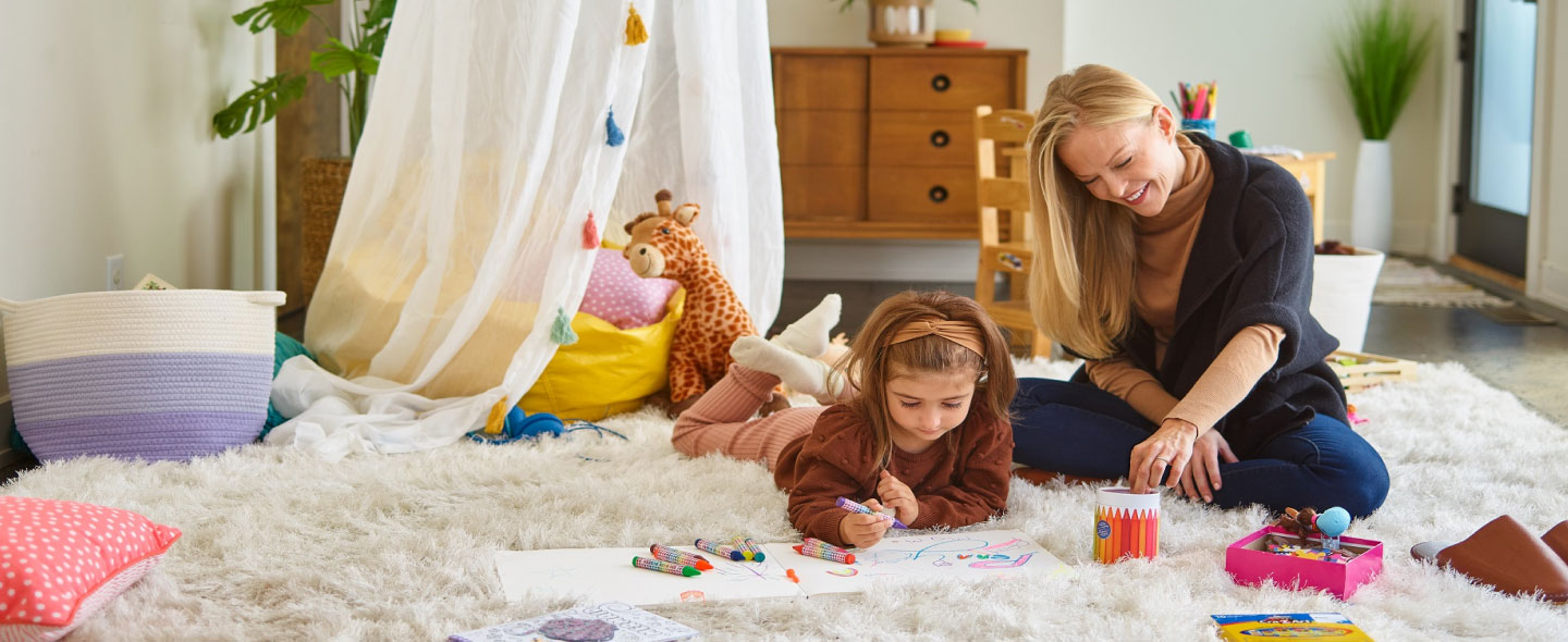 Mother and daughter playing together, smiling and enjoying quality time outdoors.