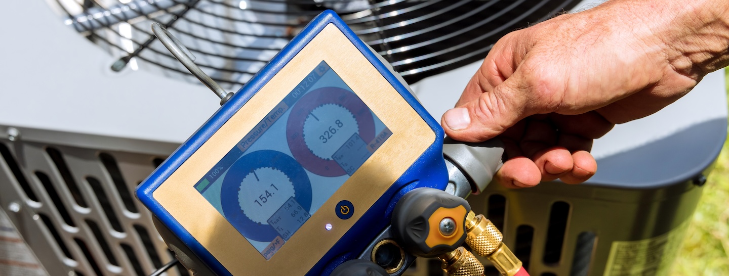 Air repair mechanic fixing using measuring equipment for filling air conditioners